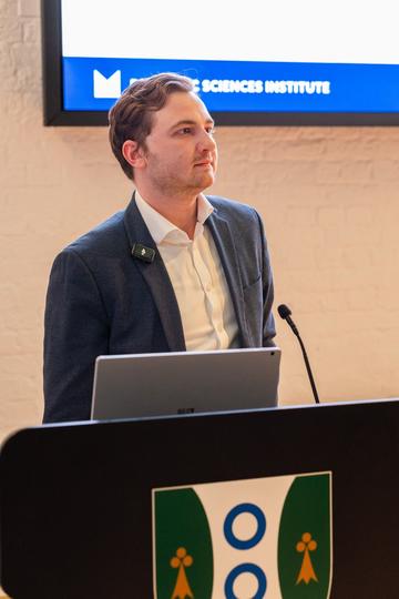 A student speaker at a podium, listening to a question