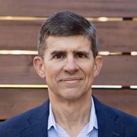 George Savage, a smartly-dressed Caucasian man with dark features and hair